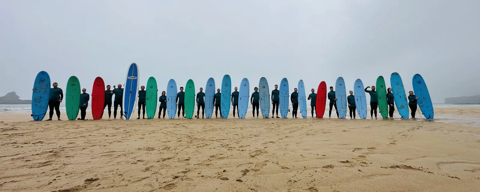 Bunte Surfboard-Reihe mit der Gruppe am Strand in Spanien