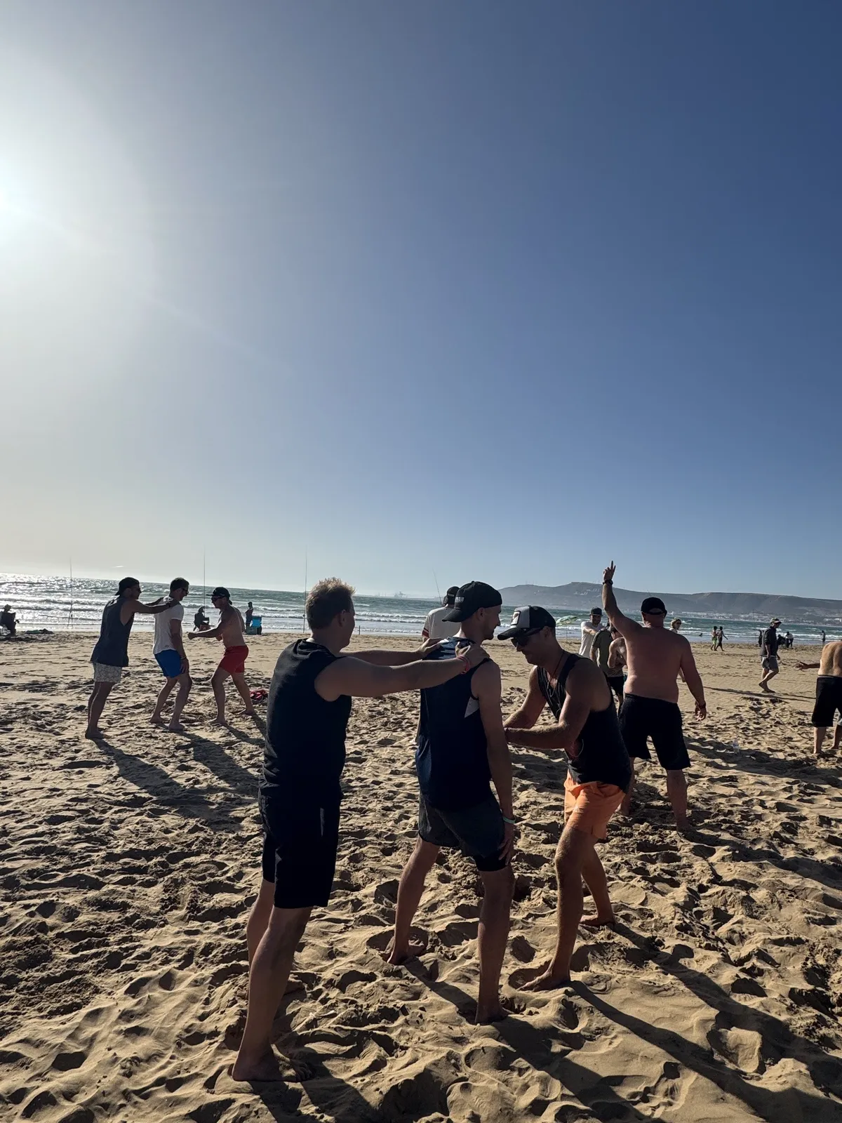 Gruppe beim Spiel am Strand im Abendlicht